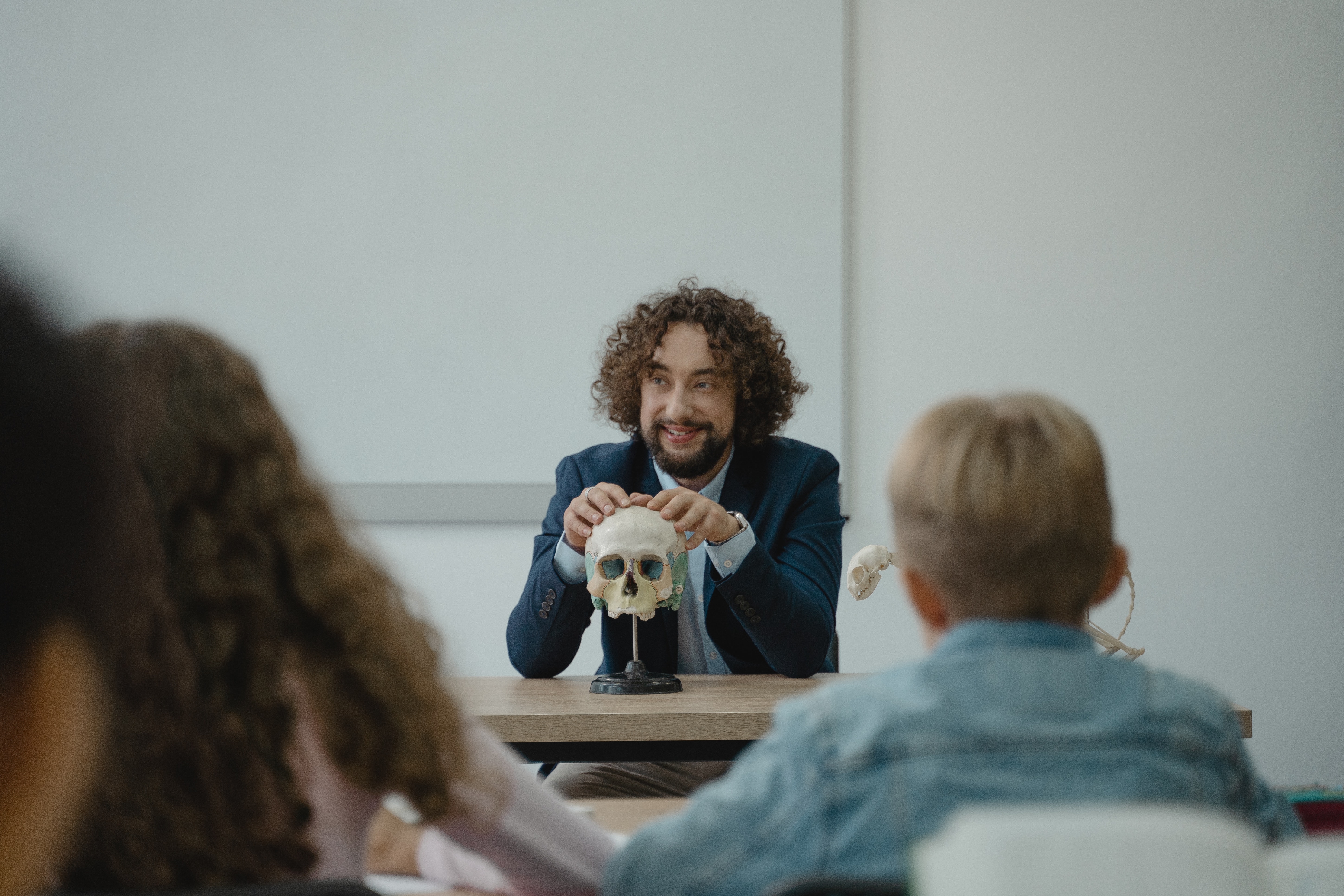 Teacher pointing to a skeleton in a classroom